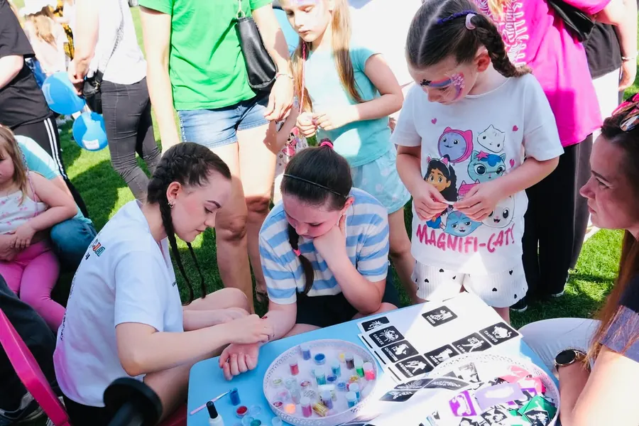 Dzieci przy stoliku z bransoletkami i kreatywnymi zabawami